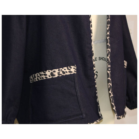 Handmade dark denim jacket with bold leopard print trim along the collar, cuffs, pockets, and hem. Featured oversized front patch pockets and relaxed, unlined silhouette. Ethically made in the USA from upcycled deadstock fabric- a funky twist on a timeless layering piece.