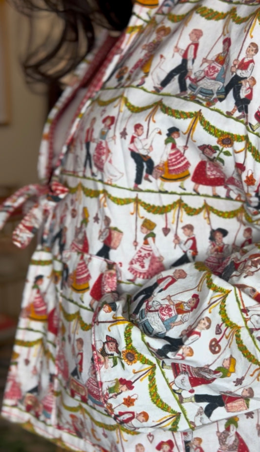 Handmade jacket featuring whimsical german scene. Trimmed in red gingham and finished with a playful front tie closure. Ethically sewn in the USA from rescued vintage cotton. Lightweight, breathable, and perfect for statement layering.