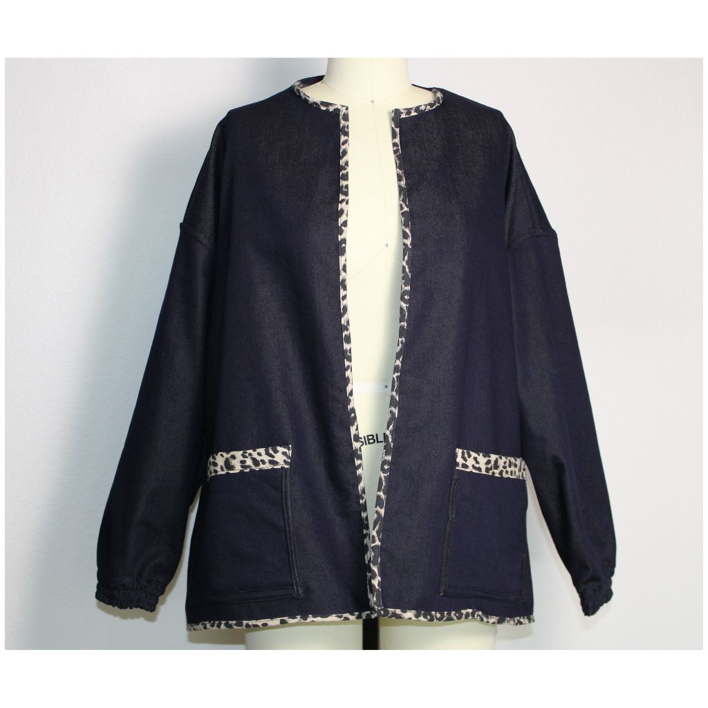 Handmade dark denim jacket with bold leopard print trim along the collar, cuffs, pockets, and hem. Featured oversized front patch pockets and relaxed, unlined silhouette. Ethically made in the USA from upcycled deadstock fabric- a funky twist on a timeless layering piece. 
