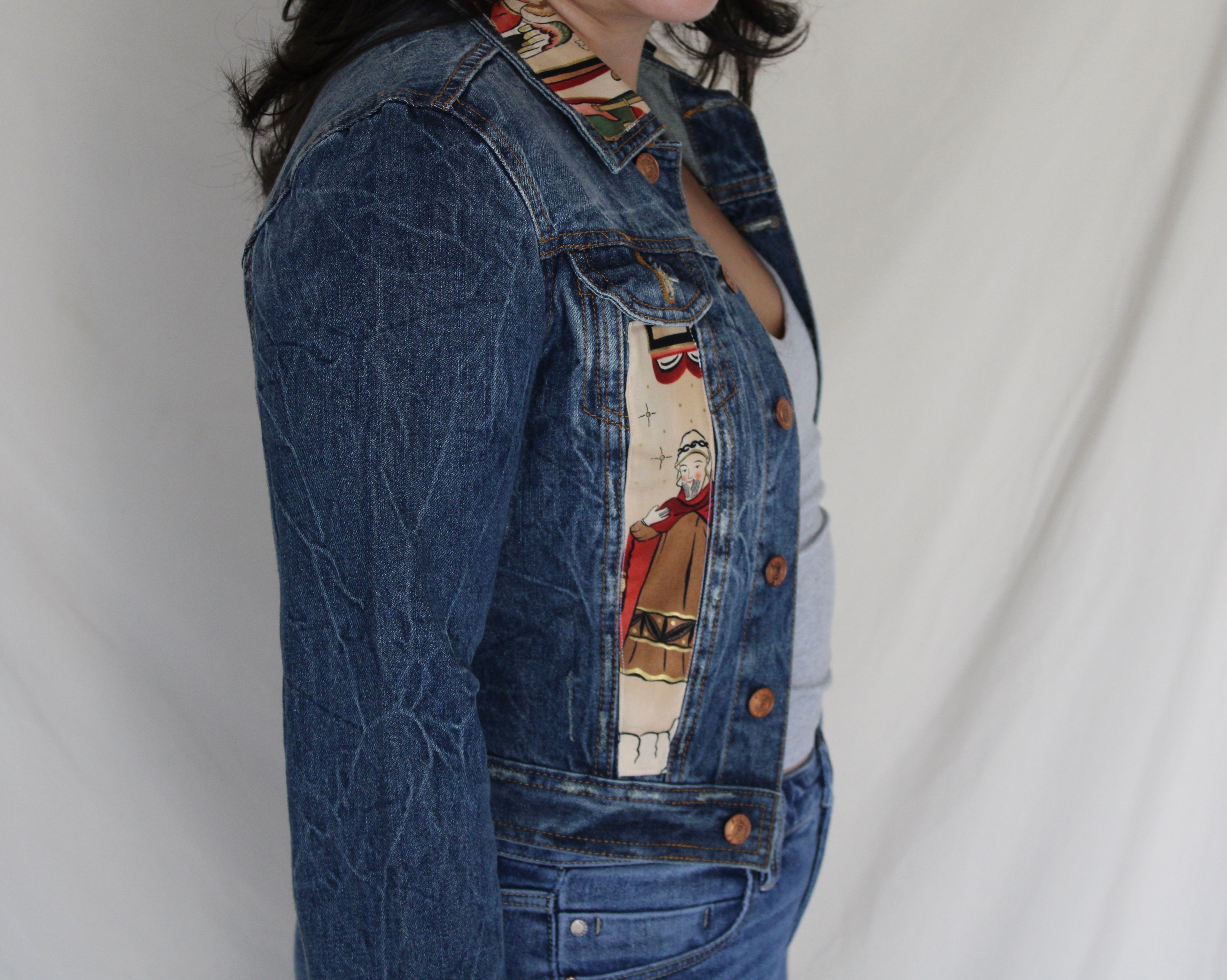 Handmade denim jacket featuring a vintage Catholic sewn into the center, repurposed from deadstock denim and designed for bold, sustainable streetwear. 