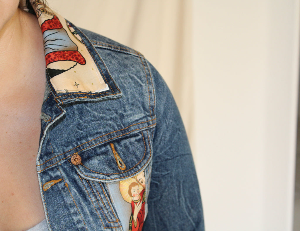 Handmade denim jacket featuring a vintage Catholic sewn into the center, repurposed from deadstock denim and designed for bold, sustainable streetwear. 