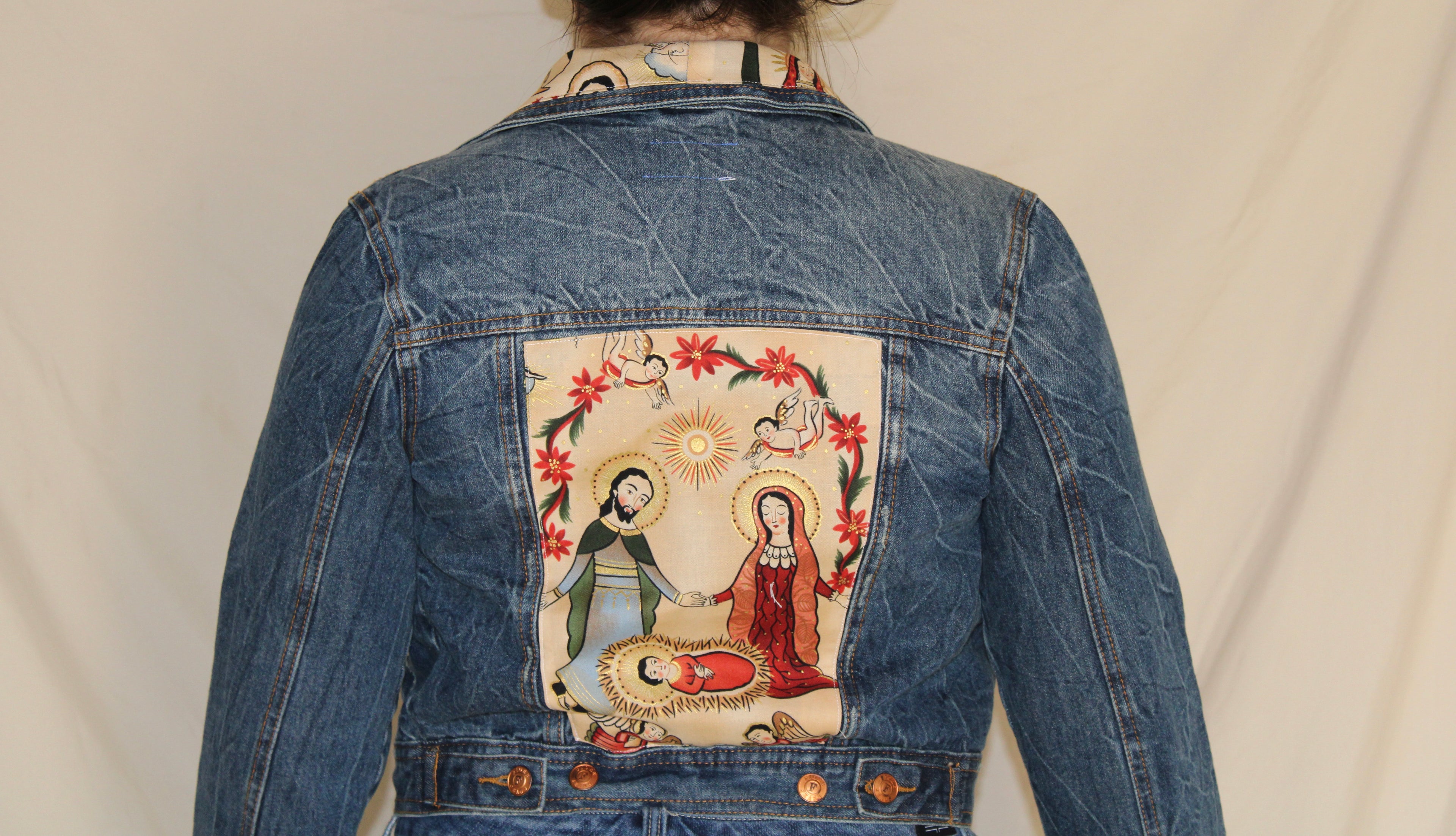 Handmade denim jacket featuring a vintage Catholic sewn into the center, repurposed from deadstock denim and designed for bold, sustainable streetwear. 
