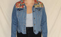 Upcycled denim jacket with scalloped hem and a bold red vintage cowboy panel on the back. Features a lassoing rodeo rider and cactus print, finished with a western-inspired collar and contrast stitching. Handmade for a one-of-a-kind, sustainable statement piece. 