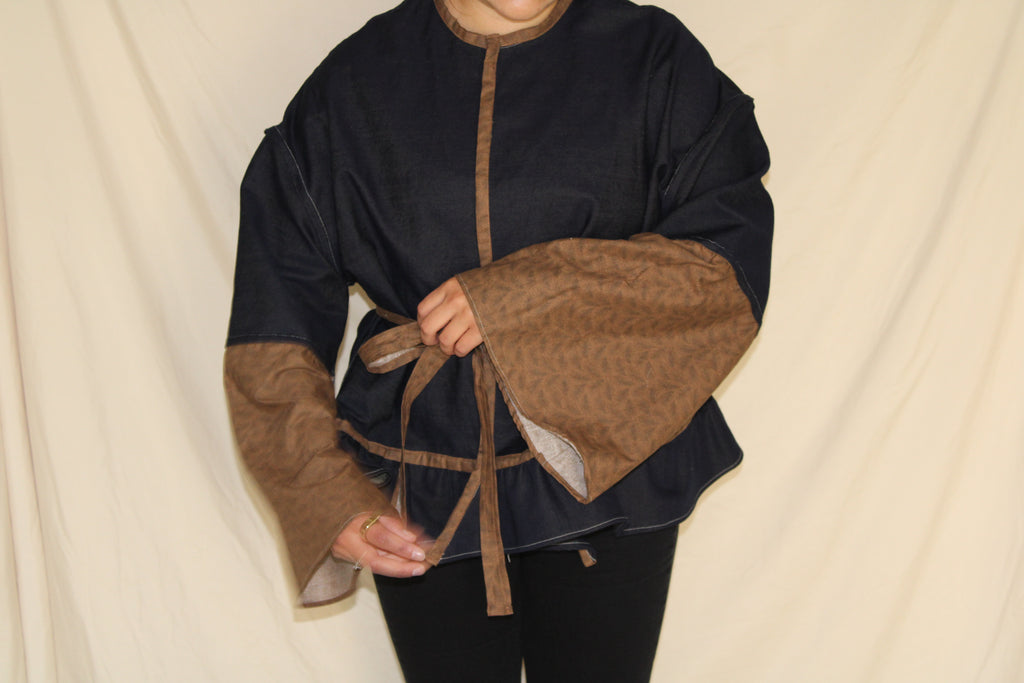 Handmade black and brown western jacket with oversized bellbottom sleeves crafted from up cycled fabric. sustainable, statement outwear with a dramatic silhouette and belted waist. 
